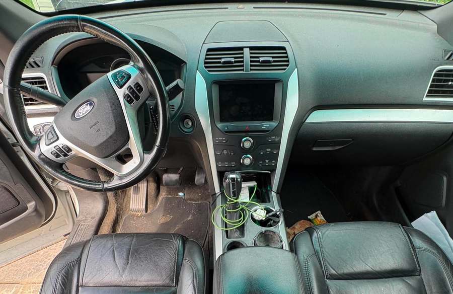 Ford Explorer console and floor cluttered and dusty before an interior detail